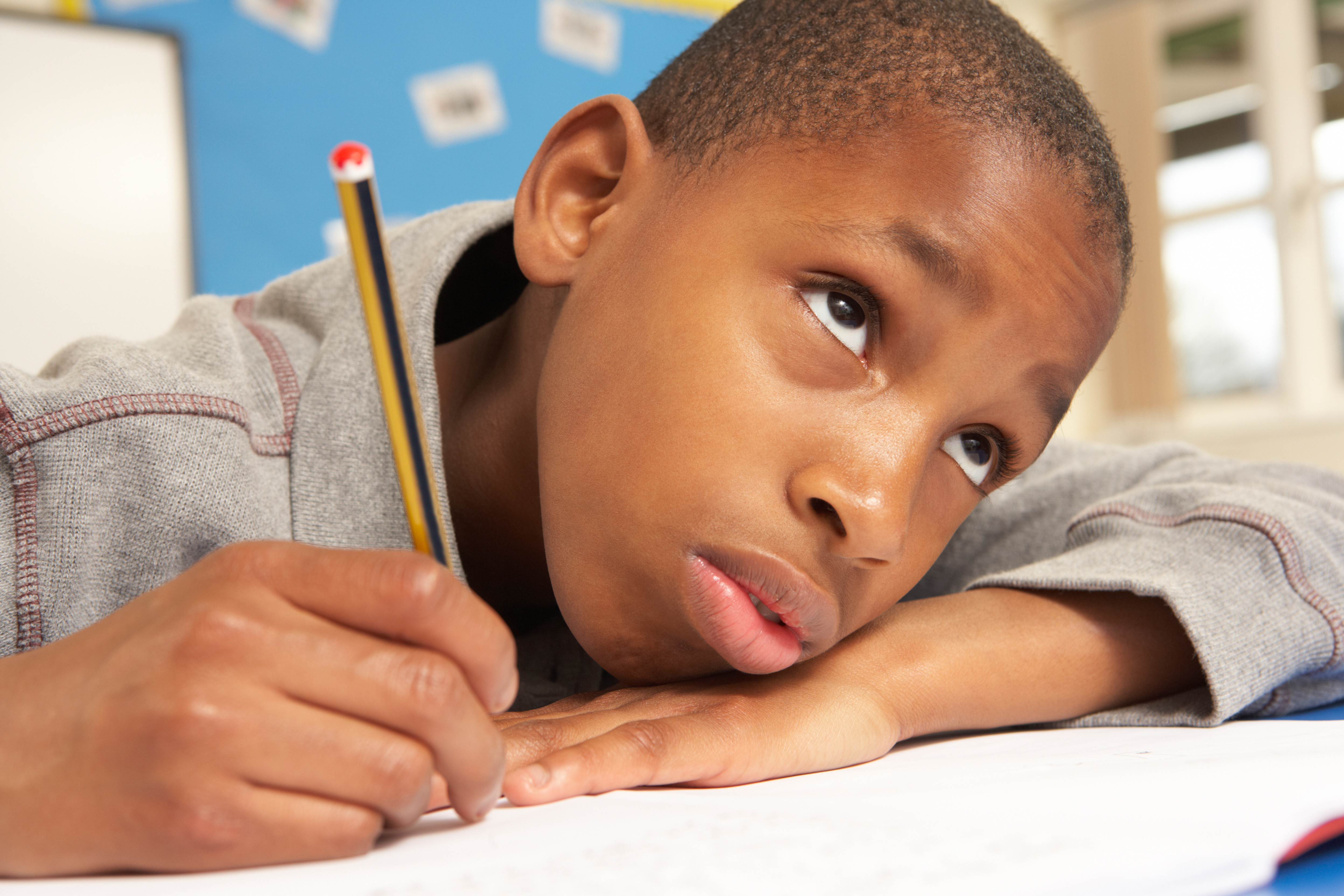 Unhappy Schoolboy Studying In Classroom